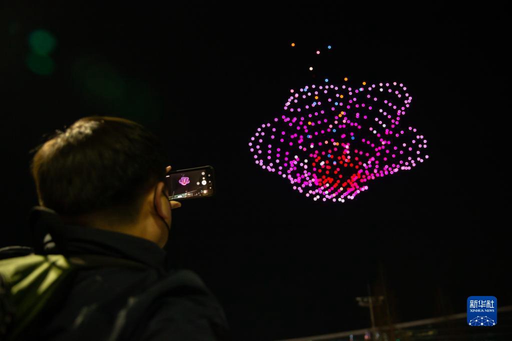 2月23日，參觀者在韓國釜山用手機拍攝2023韓國無人機展上的無人機燈光表演。
