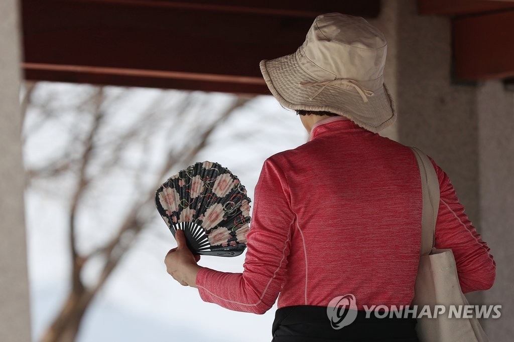 22日下午，在首爾城東區應峰山上，市民正在扇扇子降溫。