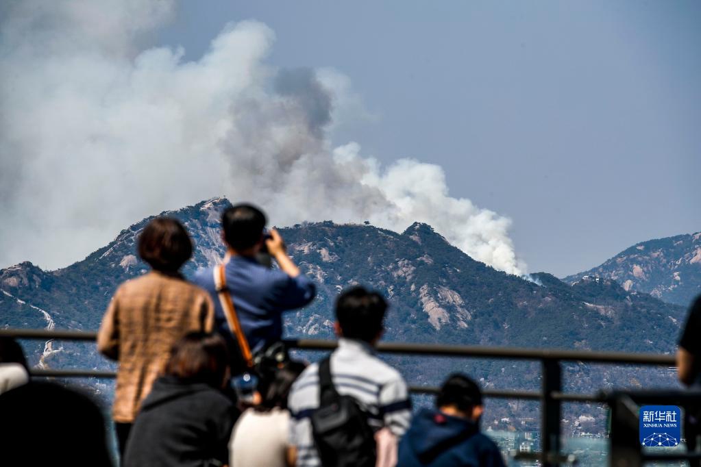 4月2日，市民在韓國首爾市眺望遠處發生山火的仁王山。新華社/紐西斯通訊社