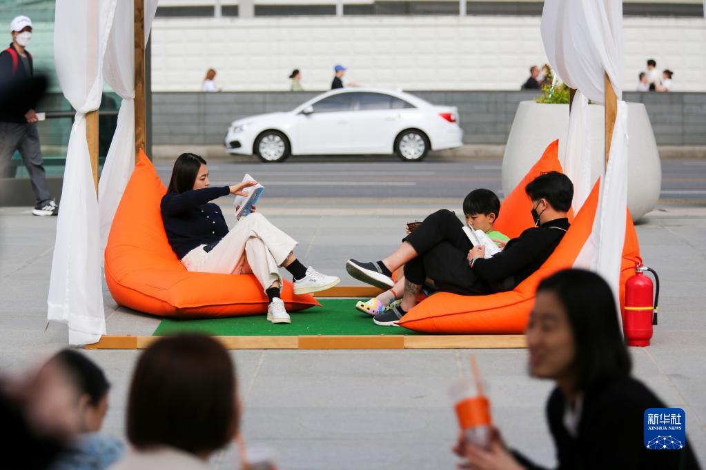 4月23日，人們在韓國首爾光化門廣場閱讀和休息。新華社記者 王益亮 攝