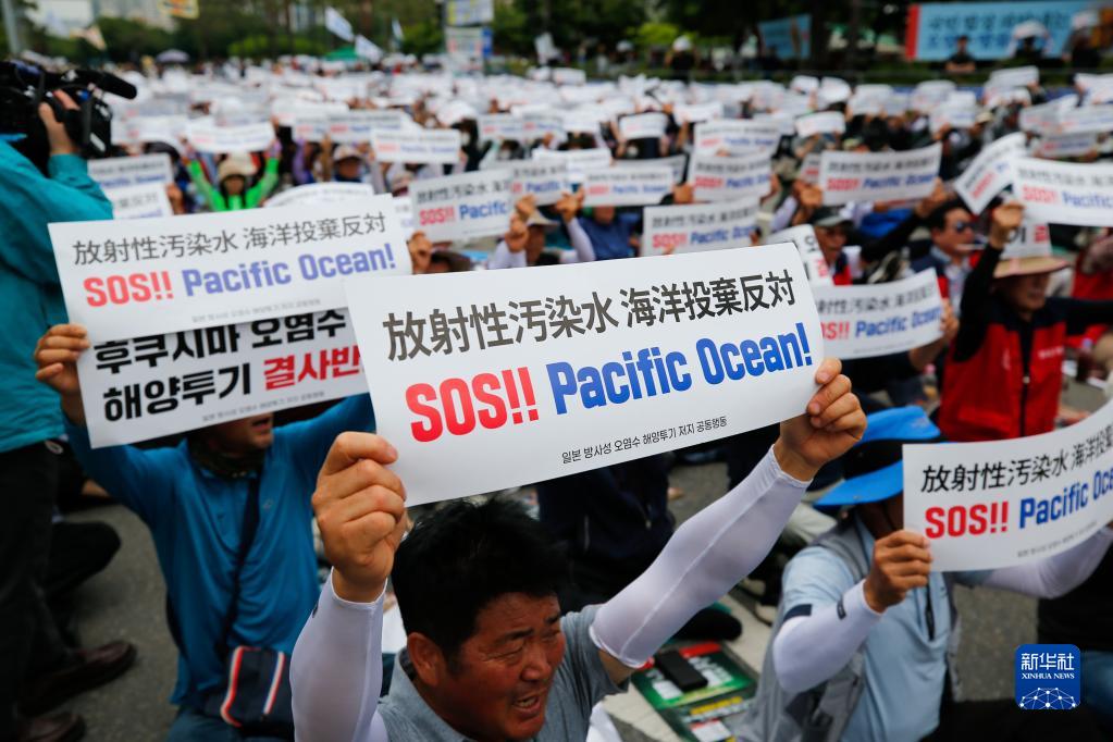 6月12日，民众在韩国首尔手举标语牌参加集会，反对日本核污染水排海。新华社记者 王益亮 摄