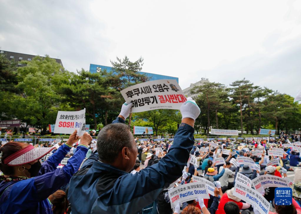 6月12日，民眾在韓國首爾手舉標語牌參加集會，反對日本核污染水排海。新華社記者 王益亮 攝