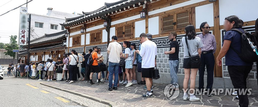 7月10日，初伏前一天，首爾市內一家參雞湯店前擠滿了排隊等位的顧客。
