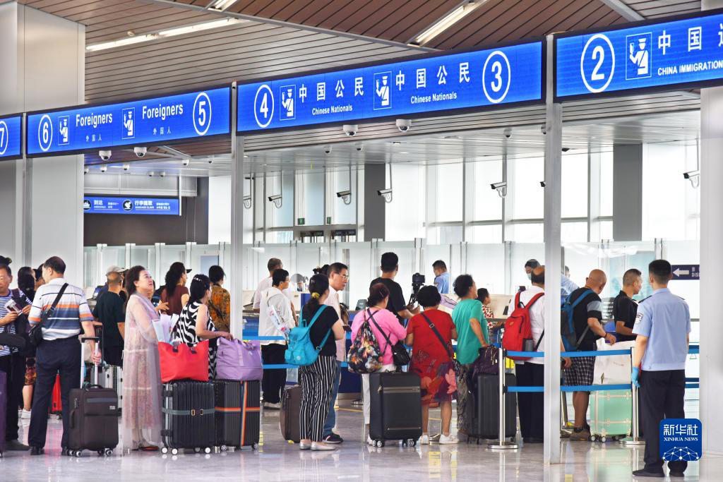 8月11日，旅客在青島郵輪母港客運碼頭排隊辦理邊檢出境手續。新華社記者 李紫恆 攝