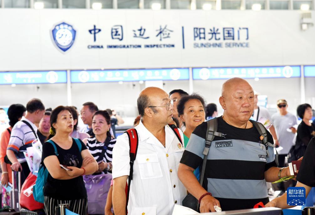8月11日，旅客在青島郵輪母港客運碼頭排隊辦理邊檢出境手續。新華社記者 李紫恆 攝