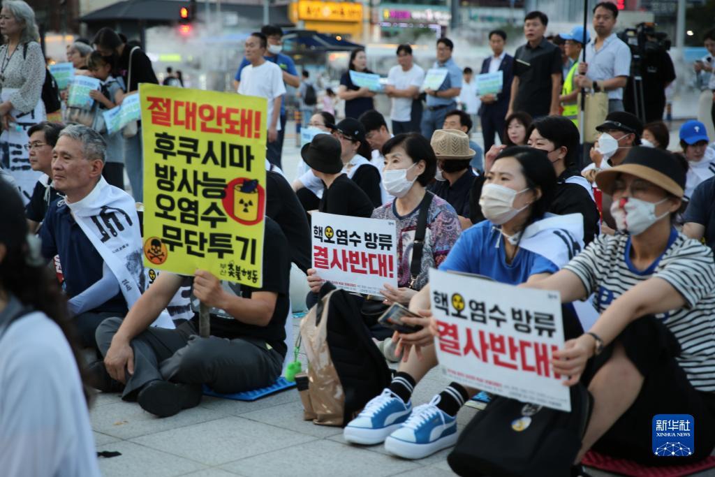 8月26日，市民手舉標語在韓國釜山火車站廣場前參加集會。新華社記者 陸睿 攝