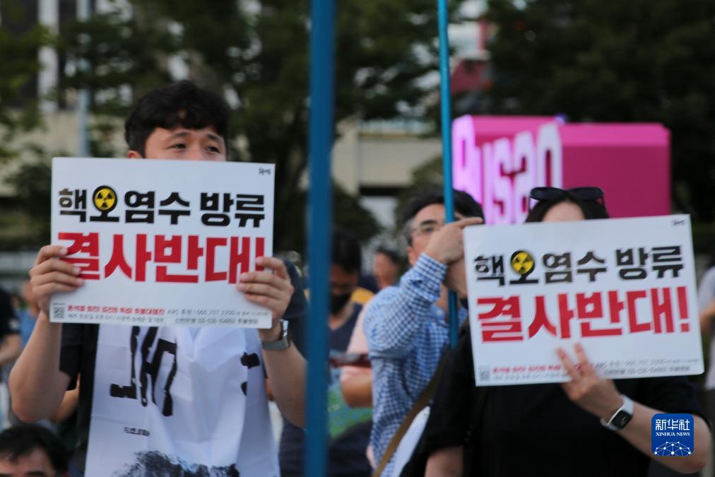 8月26日，市民手舉標語在韓國釜山火車站廣場前參加集會。新華社記者 陸睿 攝