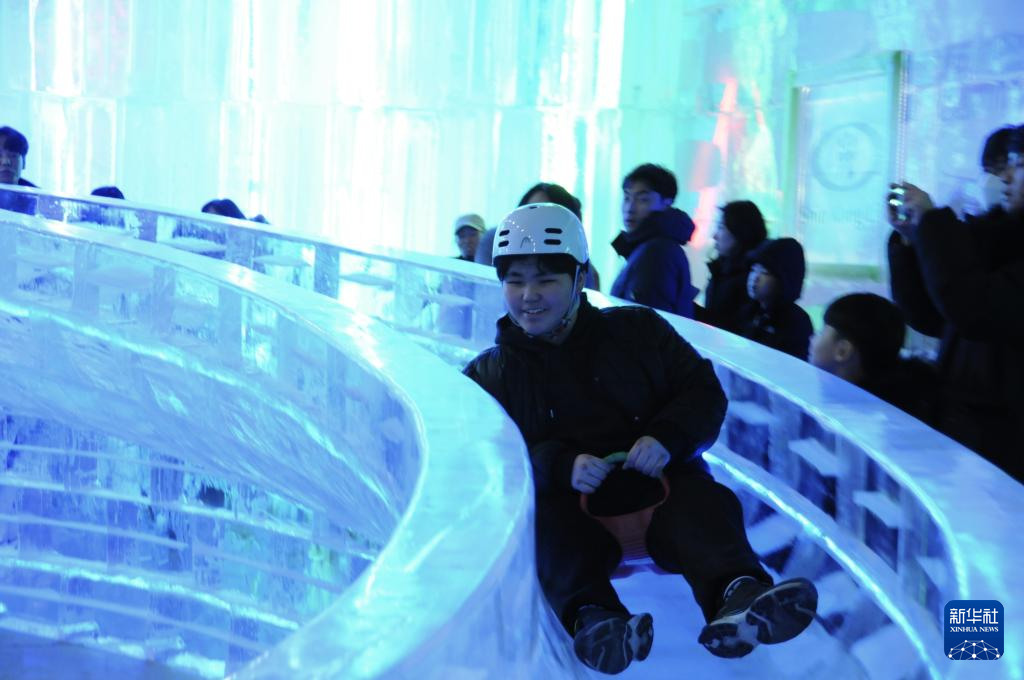 1月13日，在韓國江原道的華川山鱒魚節現場，游客體驗哈爾濱工匠制作的冰滑梯。