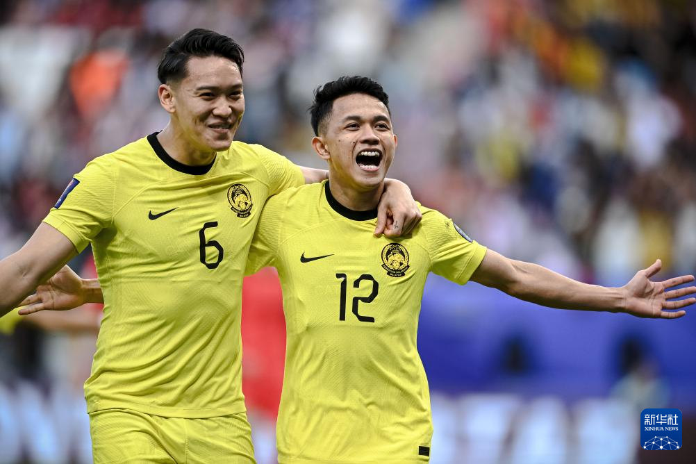 1月25日，馬來西亞隊球員阿裡夫·艾曼（右）在比賽中主罰點球得分后慶祝。新華社記者 江漢 攝