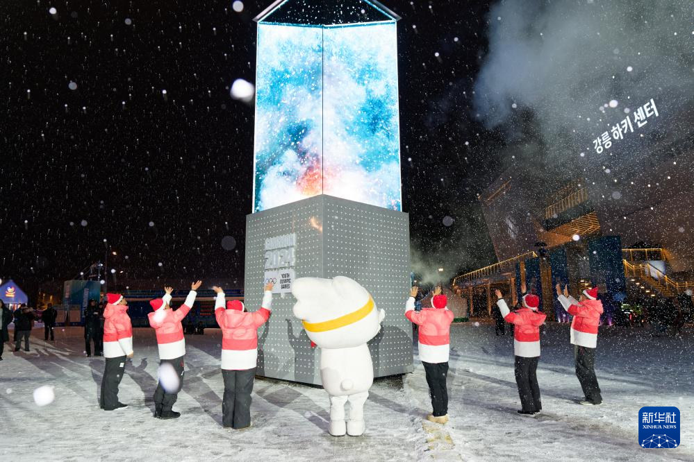 2月1日，冬青奧會吉祥物“萌吉奧”和志願者向電子火炬拋洒雪花以熄滅電子火炬。新華社記者 張笑宇 攝