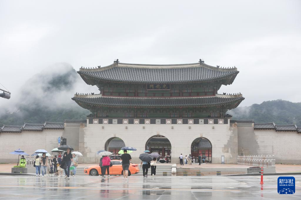 7月18日，游客冒雨游覽韓國首爾的景點。