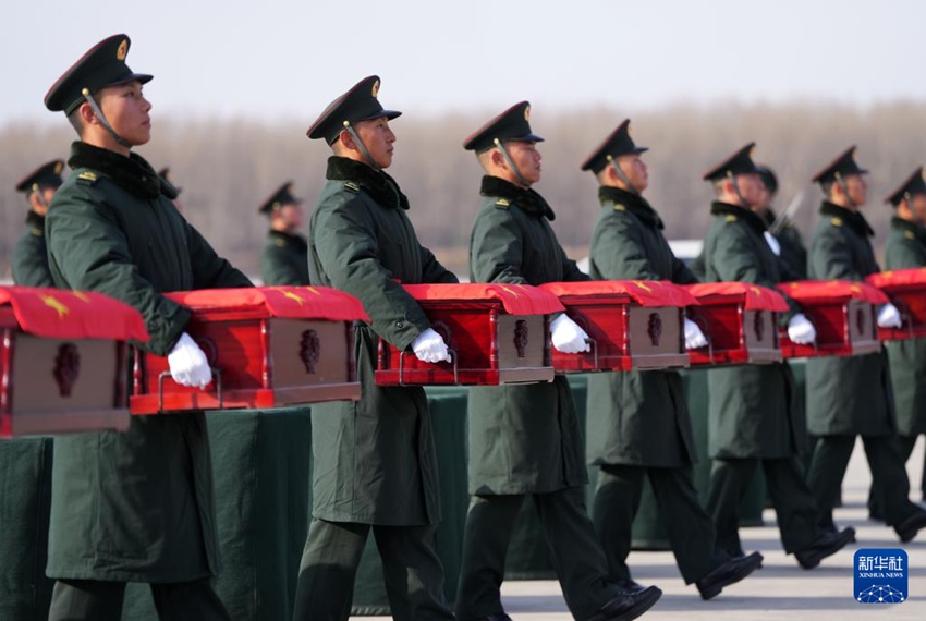 當日，在沈陽桃仙國際機場，禮兵將殮放志願軍烈士遺骸的棺槨從專機上護送至棺槨擺放區。新華社記者 李鋼 攝