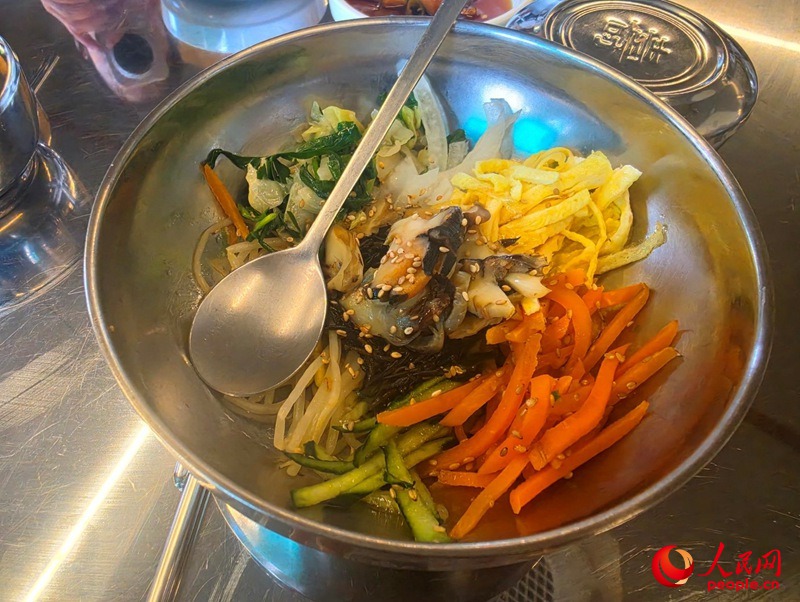 济州岛特色美食海螺拌饭，将鲜美的海螺肉与米饭、蔬菜搭配，独具海岛风味。