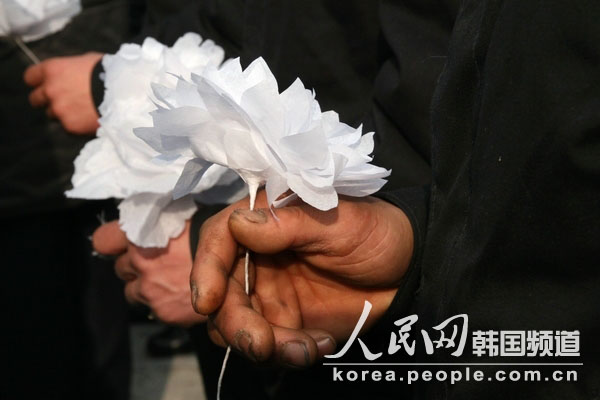 一朵朵手工制作的白花代表着朝鲜人民对金正日的无限缅怀。（人民网记者 程维丹摄）