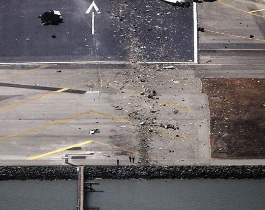 韩亚客机在美失事 韩媒还原坠毁全程准备着陆的韩亚航空客机机尾部分与机场跑道附近的防潮提冲撞。图为，脱落的机翼和碎片散落在事故现场。（韩国《朝鲜日报》图片）