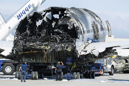 调查人员12日在拍摄韩亚航空失事客机断离的机尾部分。韩亚航空客机当地时间6日在美国旧金山国际机场降落过程中发生事故，摔断了机尾。图片来源：韩国NEWSIS