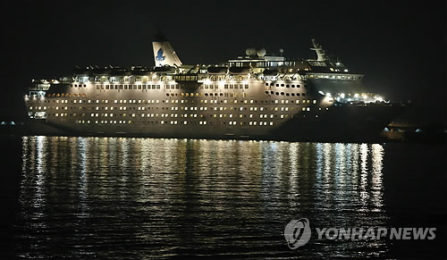在韩被扣中国客轮乘客将坐飞机回国图为13日晚，停泊在济州港的中国邮轮公司海航（HNA）旗下国际邮轮海娜号。（图片来源：韩联社）