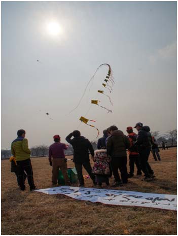 参赛者正在迎着蓝天放飞寄托新的一年美好愿望的风筝