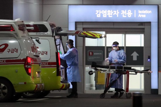 2022年3月22日，在韓國首爾，急救醫療中心醫務人員對救護車和擔架進行消毒。新華社/紐西斯通訊社