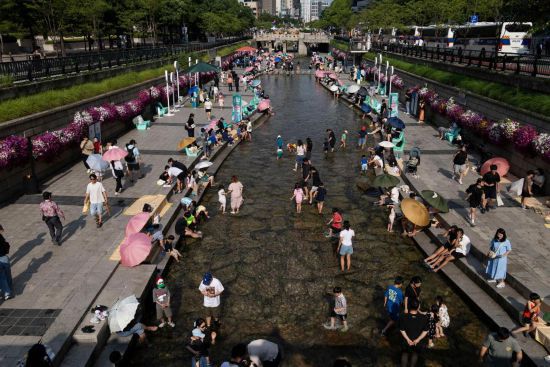 6月14日，人们在韩国首尔的清溪川戏水。新华社发（全休相摄）